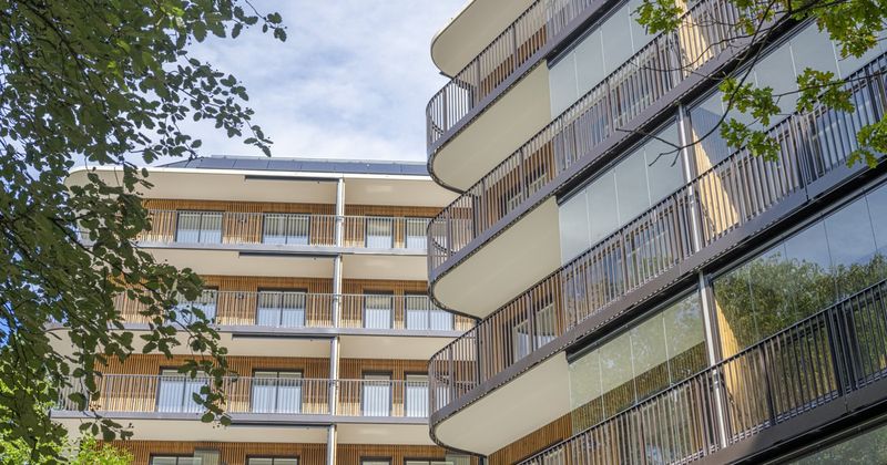 Bergshamra trygghetsboende, fasad på två hus med balkonger och träd framför.